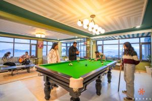 a group of people playing pool in a room with a pool table at Zostel Kufri in Kūfrī