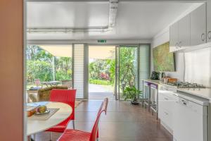 a kitchen and dining room with a table and chairs at ArtHOUSE Beachfront Accommodation in Emerald Beach
