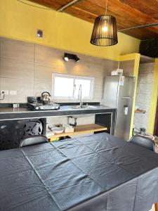 een keuken met een tafel, een wastafel en een koelkast bij ecolodge in San Pedro