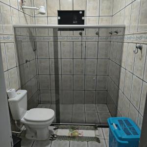een badkamer met een toilet en een betegelde muur bij Casa Temporada Prado-BA in Prado +4 foto's