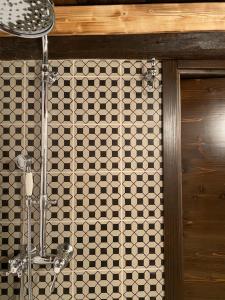a bathroom with a shower with a tiled wall at La Casetta in Bannio +12 photos