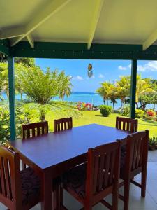 a table on a porch with a view of the ocean at The Pointe Taveuni in Matei