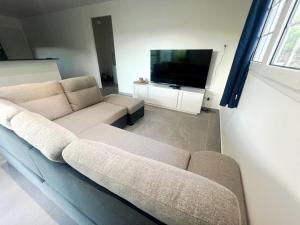 un soggiorno con divano e TV a schermo piatto di Belle petite maison Les Trois-Îlets a Les Trois-Îlets