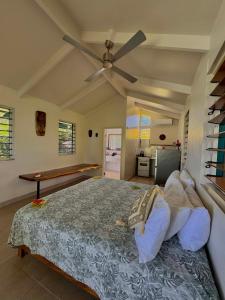 a bedroom with a bed with a ceiling fan at The Pointe Taveuni in Matei