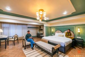 two people sitting in a hotel room with a bed at Zostel Kufri in Kūfrī
