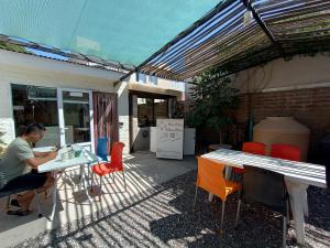 a man sitting at a table in a patio at Ruca Kiñe Hostel in Las Grutas