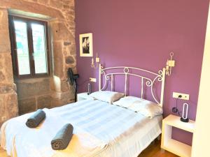 een slaapkamer met een wit bed met paarse muren bij A Casa de Feli in Muros