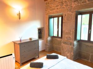 een slaapkamer met een bed, een dressoir en ramen bij A Casa de Feli in Muros