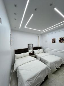 twee bedden in een kamer met witte muren bij Queen of the Nile in Luxor