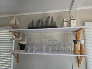 een plank met glazen en vazen erop bij Sunrise on the Tamar in Deviot