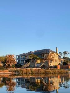 a house sitting next to a body of water at Bayou Breeze Retreat in Orange Beach