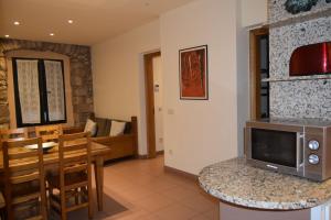 a kitchen and living room with a table and a microwave at Apartments Historic in Girona