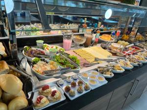 a buffet line with many different types of food at Flat espaçoso e estiloso na Praia do Bessa a uma quadra do mar! in João Pessoa