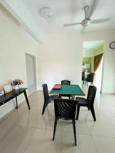 a dining room with a green table and chairs at 1091 LUX Conner in Port Dickson