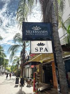 ein Schild für ein Geschäft in einer Straße mit Palmen in der Unterkunft SILVERSANDS Hotel Boutique - 5Th Ave in Playa del Carmen