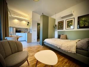 a bedroom with a bed and a chair and a table at Apartamenty Młyńska 3A in Gliwice