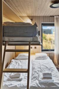 two bunk beds in a small room with a window at Hoda Cabin - Luxury lodge with jacuzzi and sauna in Lyngværet