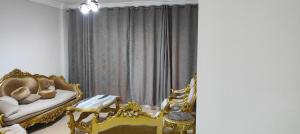 a living room with gold chairs and a couch at كومباوند وصال الشروق in Madīnat ash Shurūq