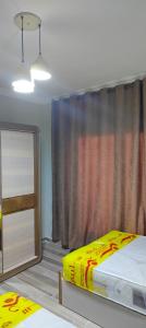 a bedroom with a bed and a dresser and a window at كومباوند وصال الشروق in Madīnat ash Shurūq