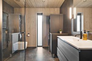 a bathroom with a sink and a toilet at Hoda Cabin - Luxury lodge with jacuzzi and sauna in Lyngværet
