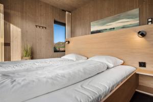 a bedroom with two beds and a large window at Hoda Cabin - Luxury lodge with jacuzzi and sauna in Lyngværet