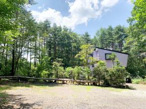 een huis in het bos met een hek bij Runesu Karuizawa - Vacation STAY 78421v in Tsumagoi