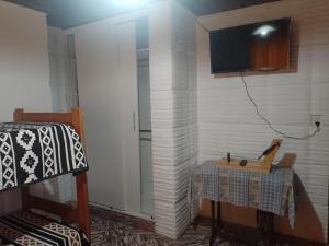 una stanza con un tavolo e una TV su una parete di Casa cómoda y familiar a Necochea