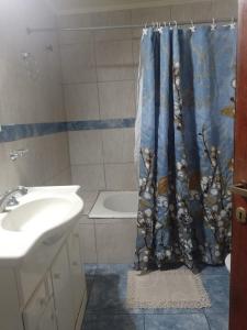 un bagno con lavandino e tenda da doccia di Casa cómoda y familiar a Necochea Altre 5 foto