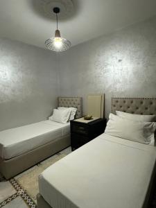 a bedroom with two beds and a lamp at Marrakech Airport in Marrakesh +6 photos