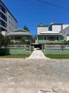 un vialetto di fronte a una casa con recinzione di Apartlaguna - 3 residenciais diferentes a Laguna