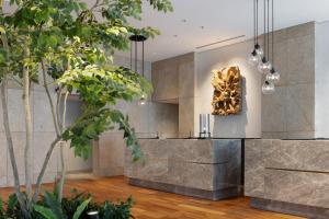 een lobby met een bronzen sculptuur aan de muur bij Miyako City Osaka Hommachi in Osaka