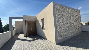 a building with a door on the side of it at Villa neuve avec une grande terrasse in Dar Tahar Zaouch