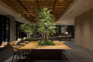 a large wooden table with trees on it in a lobby at Miyako City Osaka Hommachi in Osaka