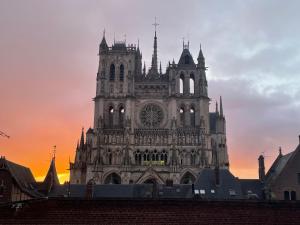 a large cathedral building with a sunset in the background at Vue Cathedrale, Elegance & Lumière à Amiens in Amiens