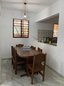 een eetkamer met een houten tafel en stoelen bij Lege Bonoua in Bonoua