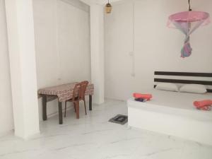 een witte kamer met een tafel en een bed bij The Banana Cottage in Udawalawe