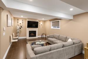 een woonkamer met een bank en een open haard bij Executive 2BR Lower Suite Private & Spacious Close to USA Border in Windsor