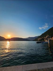 a view of a lake with the sun setting at Como Lake, lakefront 30m in Como