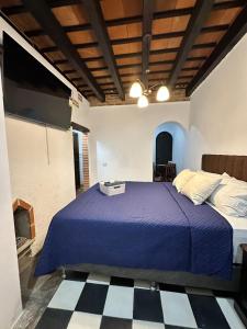 een slaapkamer met een blauw bed en een zwart-witte vloer bij Refugio de las Estrellas in Antigua Guatemala