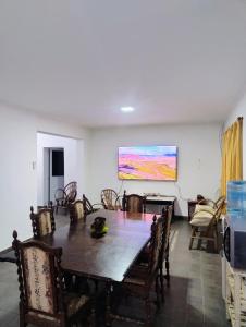 a dining room with a table and a painting on the wall at Casa Punta Iglesia in Paso de la Patria