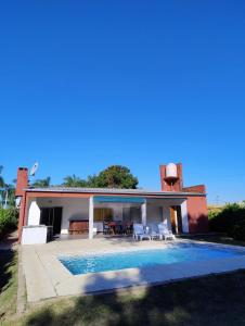a house with a swimming pool in front of it at Casa Punta Iglesia in Paso de la Patria