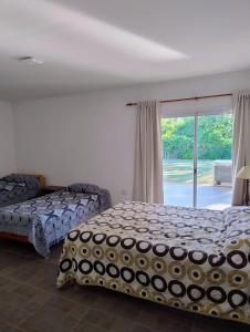 a bedroom with a bed and a sliding glass door at Casa Punta Iglesia in Paso de la Patria +8 photos
