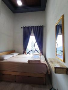 a bedroom with a bed and a window with purple curtains at Vany GLAMPING in Pasuruan