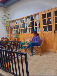 a woman sitting on a chair in a room at Vany GLAMPING in Pasuruan