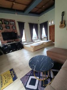 a living room with a table and a couch at Vany GLAMPING in Pasuruan