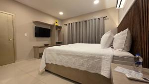 ein Hotelzimmer mit Bett und Fernseher in der Unterkunft Hotel Casa La Tablada Aeropuerto in Cartagena de Indias