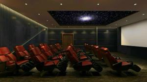 a cinema room with red chairs and a screen at Happy One Central in Trạm Chánh An +12 photos