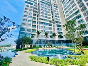 a building with a swimming pool in front of a building at Happy One Central in Trạm Chánh An