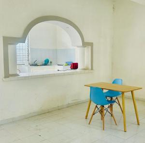a dining room with a table and two blue chairs at Casa Ich in Valladolid