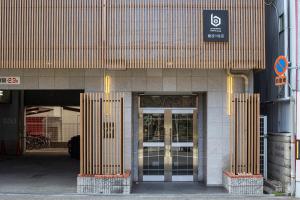 un ingresso di un edificio con due porte e un cartello di b&難波3号店 ad Osaka